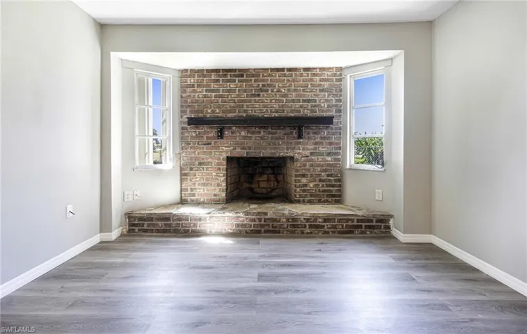 Unfurnished living room featuring wood-type flooring and a fireplace