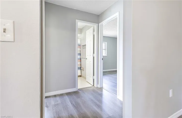 Hallway featuring light hardwood / wood-style floors and a textured ceiling