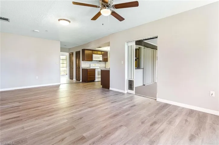 Unfurnished living room featuring ceiling fan, light hardwood / wood-style flooring, and a textured ceiling