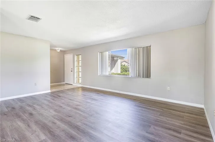 Spare room with dark hardwood / wood-style flooring and a textured ceiling