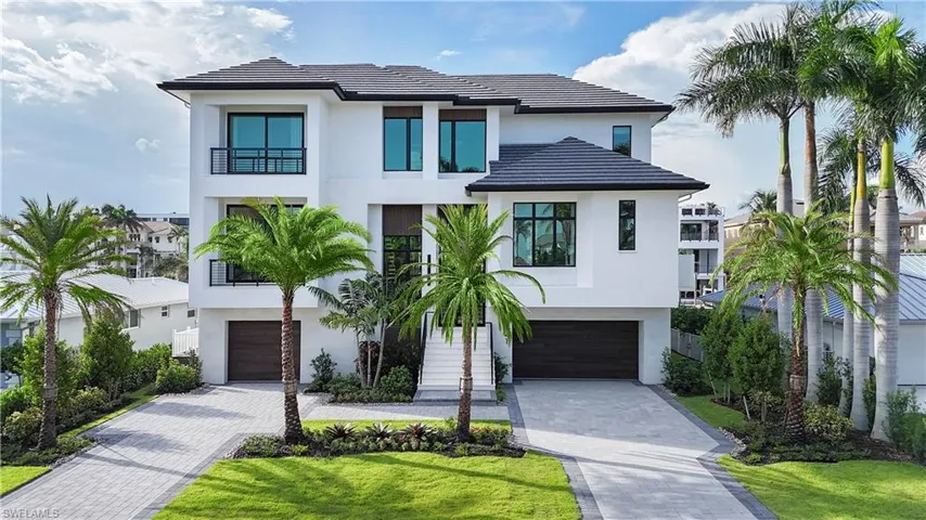Modern architectural exterior featuring a white stucco finish and a dark tile roof