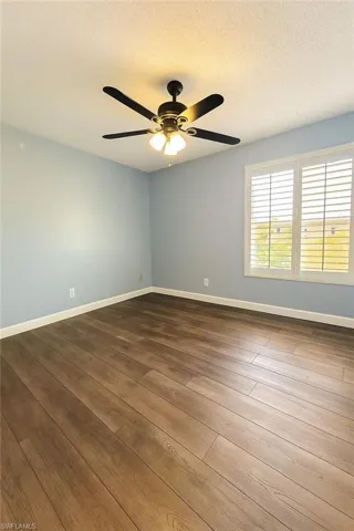 Spare room featuring LVP floors, ceiling fan, and a textured ceiling