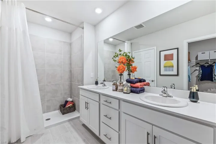 Bathroom featuring a shower with curtain and vanity