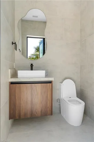 Half bath featuring vanity and tile walls