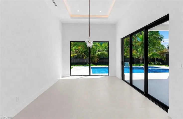 Unfurnished dining area with a high tray ceiling and a chandelier