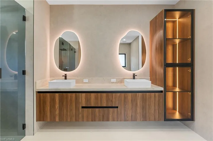 Full bathroom with double vanity and a shower stall
