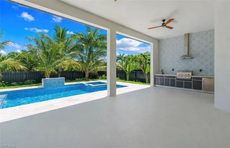 Integrated pool / spa featuring an outdoor kitchen, a patio, and a fenced backyard
