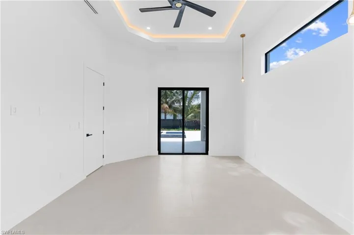 Unfurnished room with a tray ceiling, ceiling fan, recessed lighting, and concrete floors