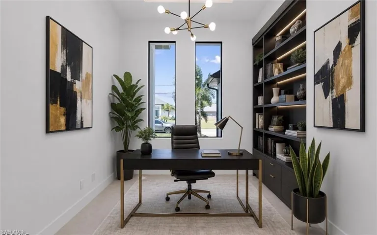 Dedicated office space featuring built-in shelving with integrated lighting, wood-finish flooring, and expansive vertical windows
