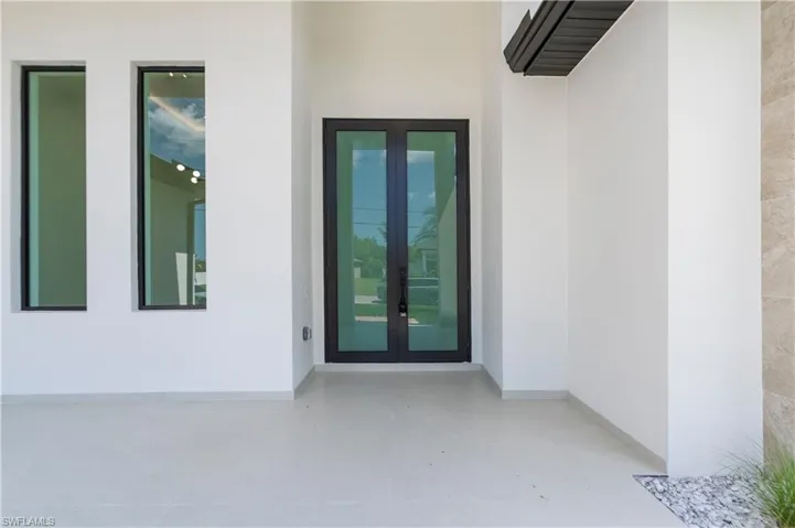 Doorway to property featuring french doors and stucco siding
