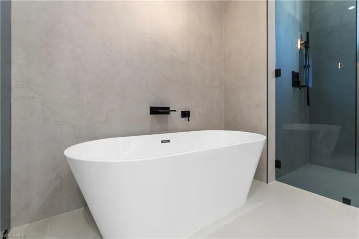 Full bathroom with a soaking tub, a stall shower, and light tile patterned flooring