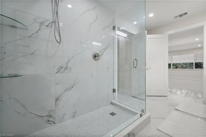 Full bath featuring a marble finish shower, light marble finish floors, and recessed lighting