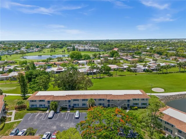 Drone / aerial view of a nearby body of water and a golf club