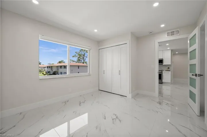 Unfurnished bedroom with light marble finish flooring, recessed lighting, and a closet