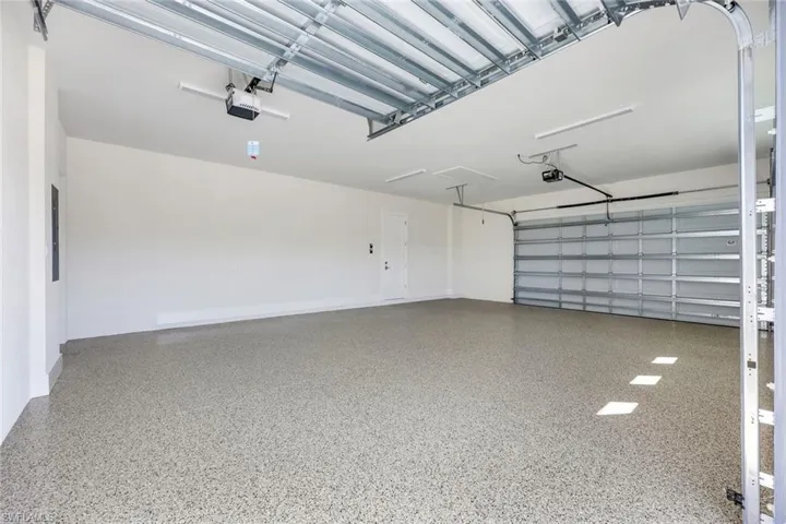 Garage featuring a garage door opener and electric panel