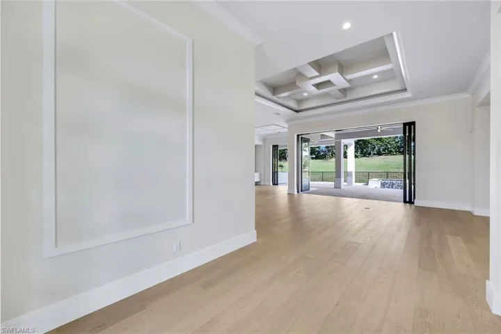 Unfurnished room featuring coffered ceiling, light wood-style floors, beam ceiling, crown molding, and recessed lighting