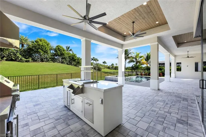 Fenced backyard with area for grilling, a ceiling fan, and a patio