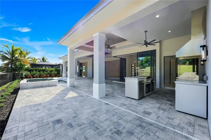 View of patio / terrace featuring area for grilling, a ceiling fan, and an in-ground hot tub