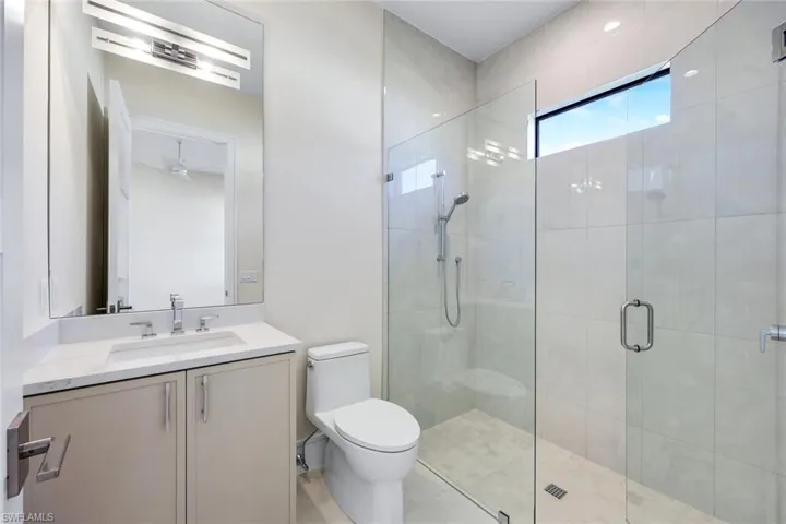 Bathroom featuring a shower stall and vanity