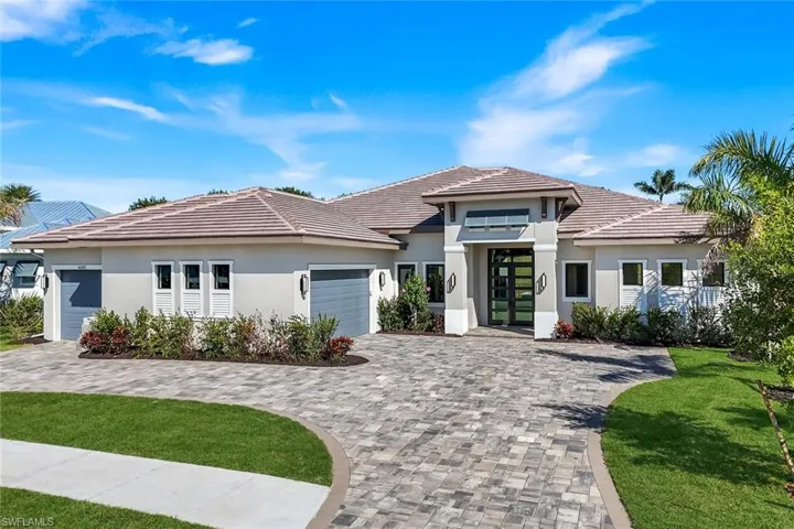 Prairie-style home featuring french doors, decorative driveway, a garage, stucco siding, and a front yard