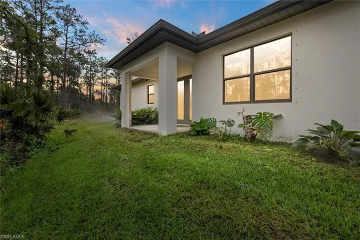 View of home's exterior with a lawn and stucco siding