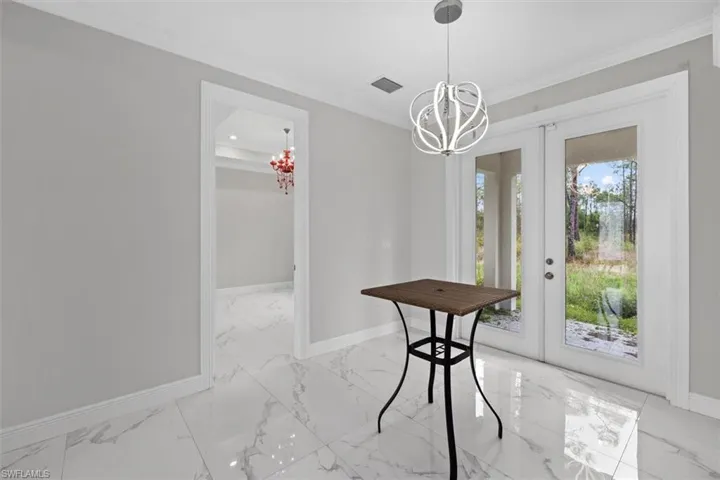 Dining room with crown molding, marble finish floor, a notable chandelier, and visible vents