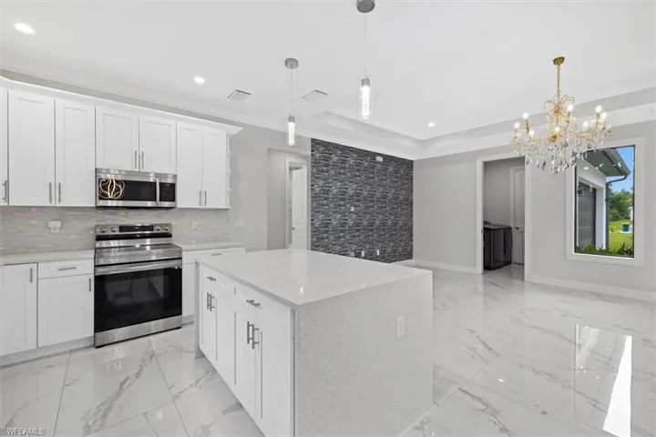 Kitchen with recessed lighting, visible vents, a raised ceiling, stainless steel appliances, and marble finish floor