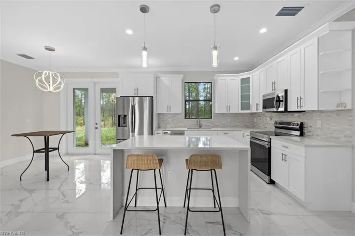 Kitchen with tile floor, a sink, open shelves, and stainless steel appliances