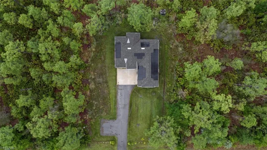 Birds eye view of property featuring a wooded view