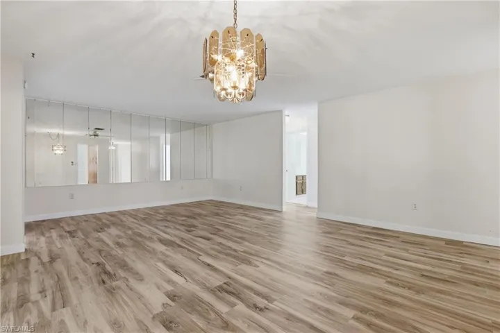 Bright formal living room with newer flooring and an open layout that creates a warm, inviting first impression.