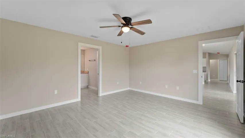 Spare room featuring ceiling fan, light wood finished floors, visible vents, and baseboards