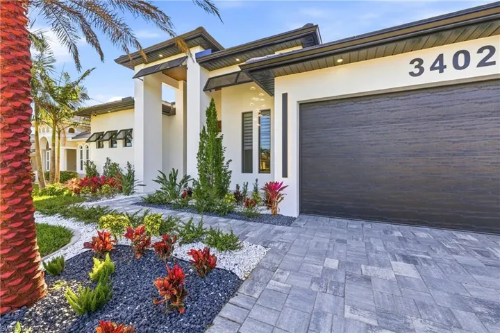 View of front of house featuring stucco siding, driveway, and an attached garage