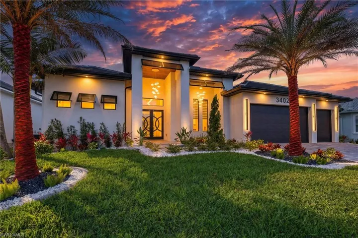 View of front of house featuring a front yard, an attached garage, stucco siding, and driveway