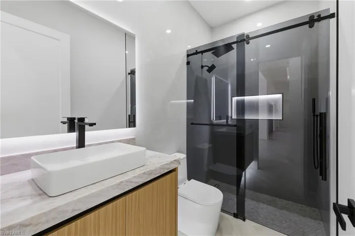 Full bath featuring a stall shower and vanity