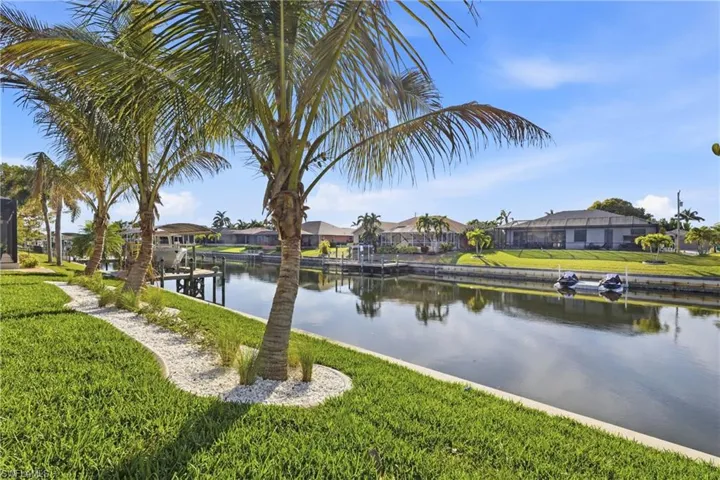 Water view featuring nearby suburban area and a boat dock