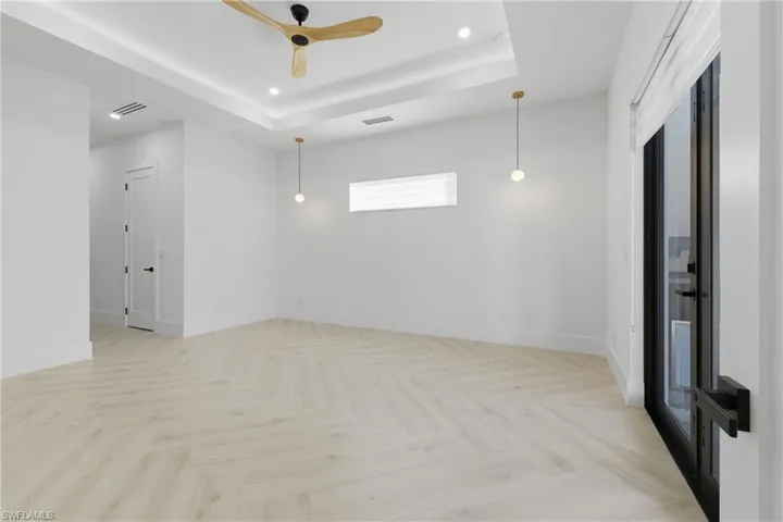 Unfurnished room with parquet flooring, a raised ceiling, recessed lighting, and a ceiling fan
