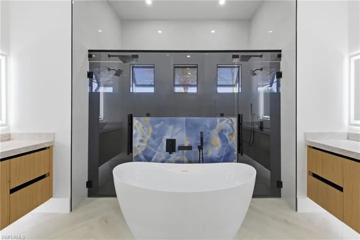 Full bath with vanity, a stall shower, and a freestanding tub