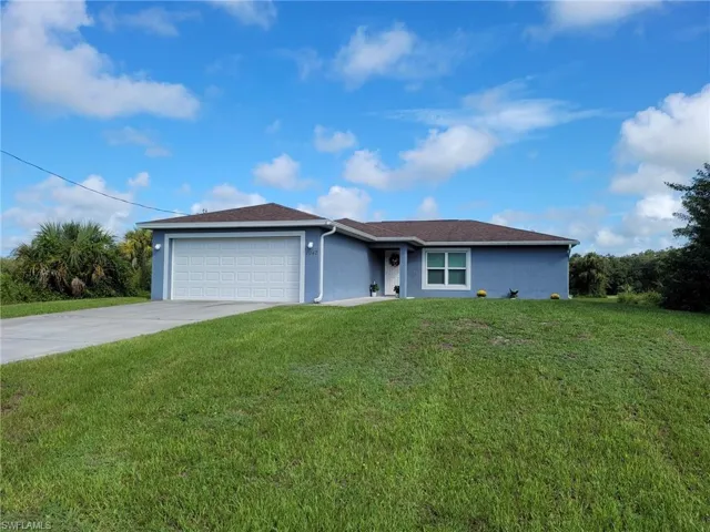 Single story home featuring a front yard and a garage