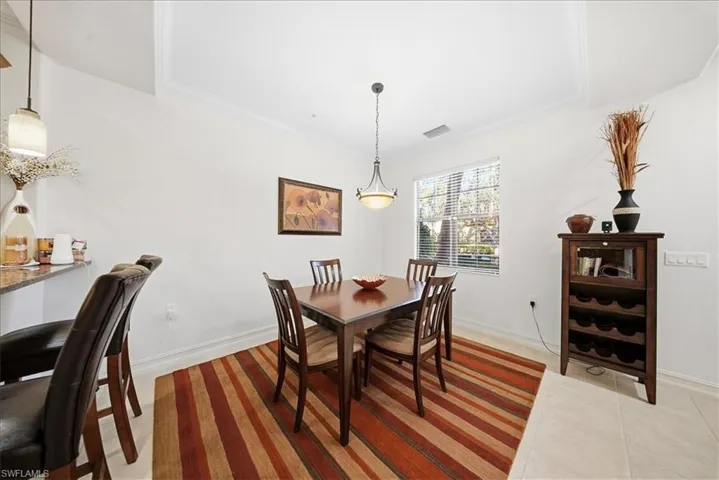 Dining space with light tile patterned floors and ornamental molding