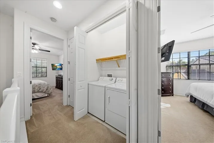 Laundry area with a ceiling fan, light carpet, washing machine and dryer, and recessed lighting