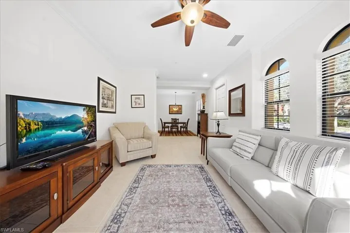 Living room with crown molding, a ceiling fan, light tile patterned flooring, and recessed lighting
