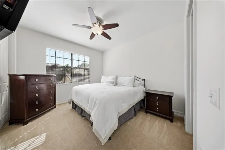 Bedroom with light colored carpet and ceiling fan