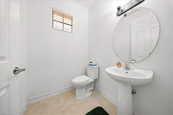 Bathroom with baseboards and light tile patterned flooring