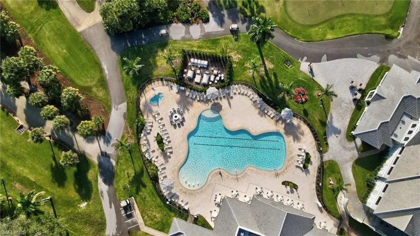Resort-style pool area featuring a freeform swimming pool, extensive paved sundeck, and a dedicated shallow wading pool