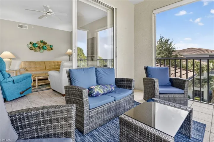 Tiled balcony featuring a black iron railing, providing an open-air extension of the interior living area with sliding glass doors
