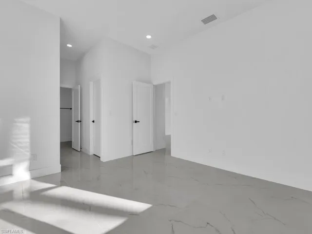 Unfurnished bedroom with light marble finish flooring and recessed lighting