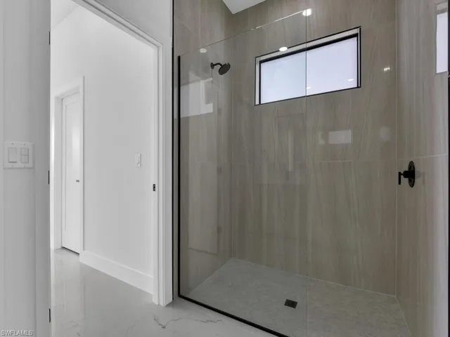 Full bath with walk in shower and baseboards
