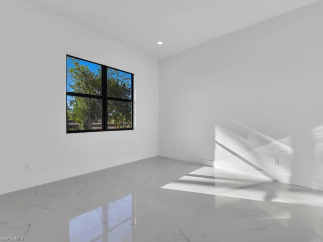 Unfurnished room with light marble finish floors and recessed lighting