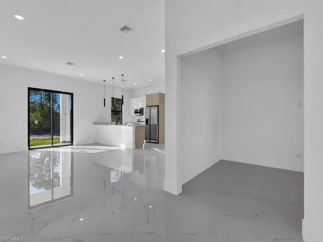 Unfurnished living room with light marble finish flooring and recessed lighting