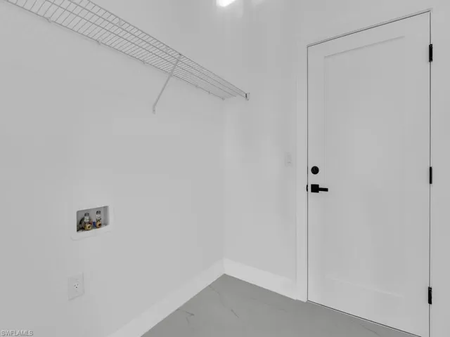 Laundry area featuring washer hookup and marble finish floors